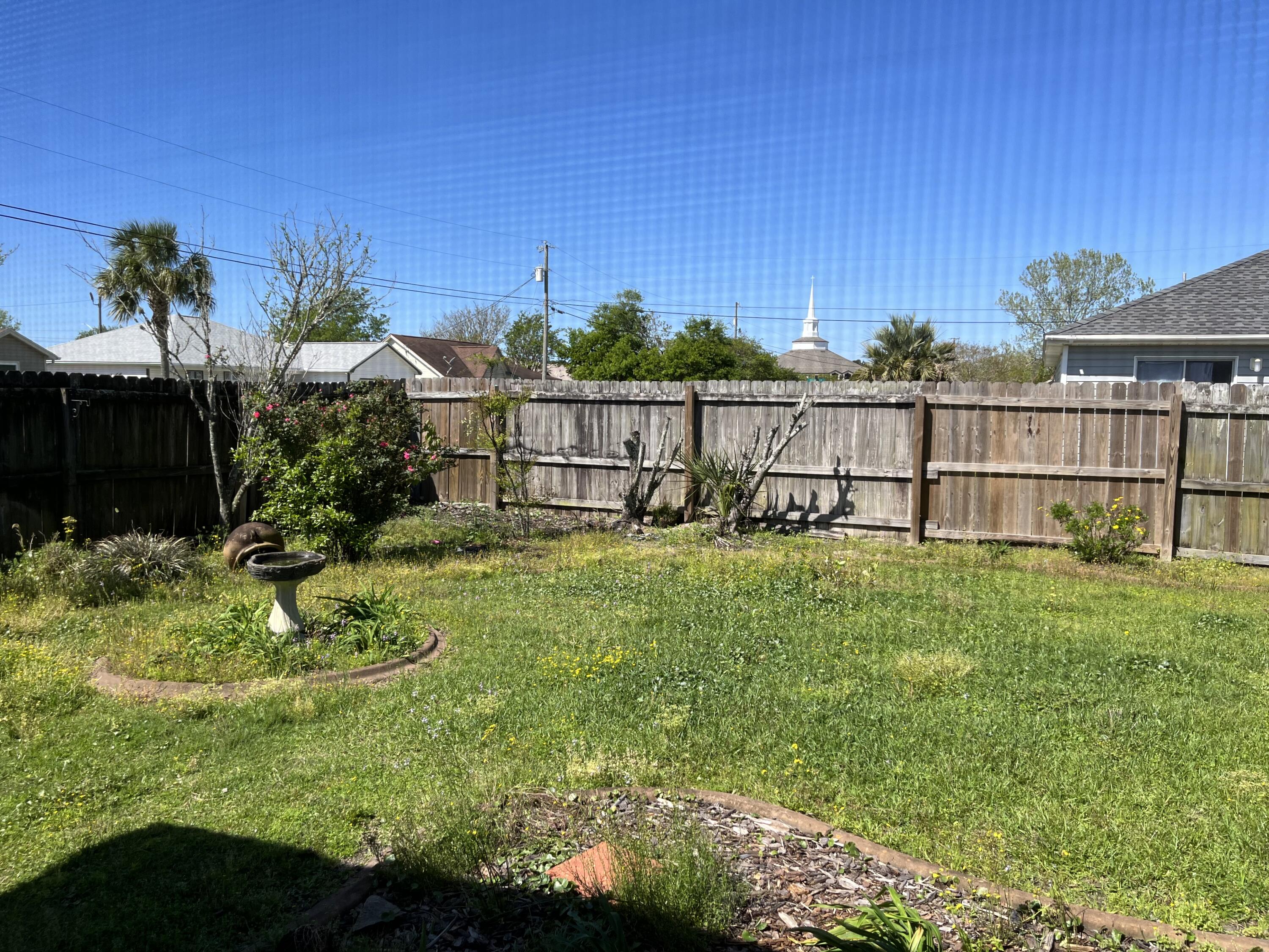 2260 Estate Circle Navarre, FL 32566 - Photo 7 of 14 a view of a garden with a building in the background