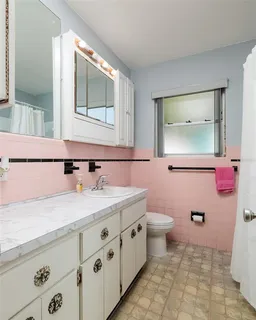 a bathroom with a granite countertop sink mirror vanity and toilet