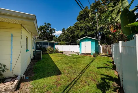 a backyard of a house with plants and a tree