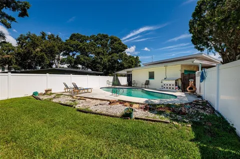 a view of a house with backyard and sitting area