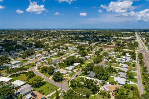 an aerial view of residential houses with outdoor space and trees all around