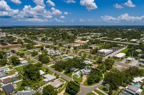 an aerial view of residential houses with outdoor space and trees