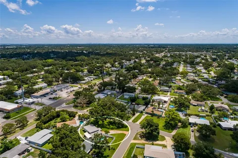 an aerial view of residential houses with outdoor space and trees