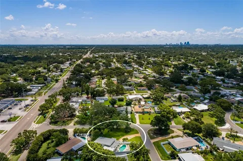 an aerial view of residential houses with outdoor space and trees