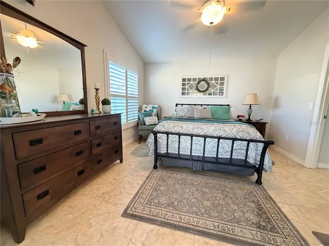 a bedroom with a bed and a mirror on dresser