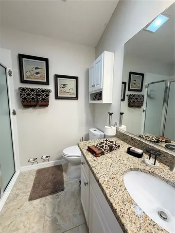 a bathroom with a granite countertop sink a toilet and a mirror