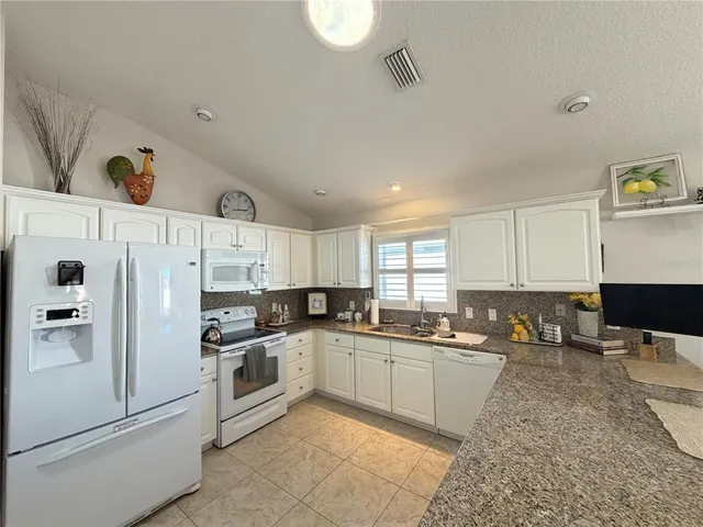 a kitchen with white cabinets and white appliances