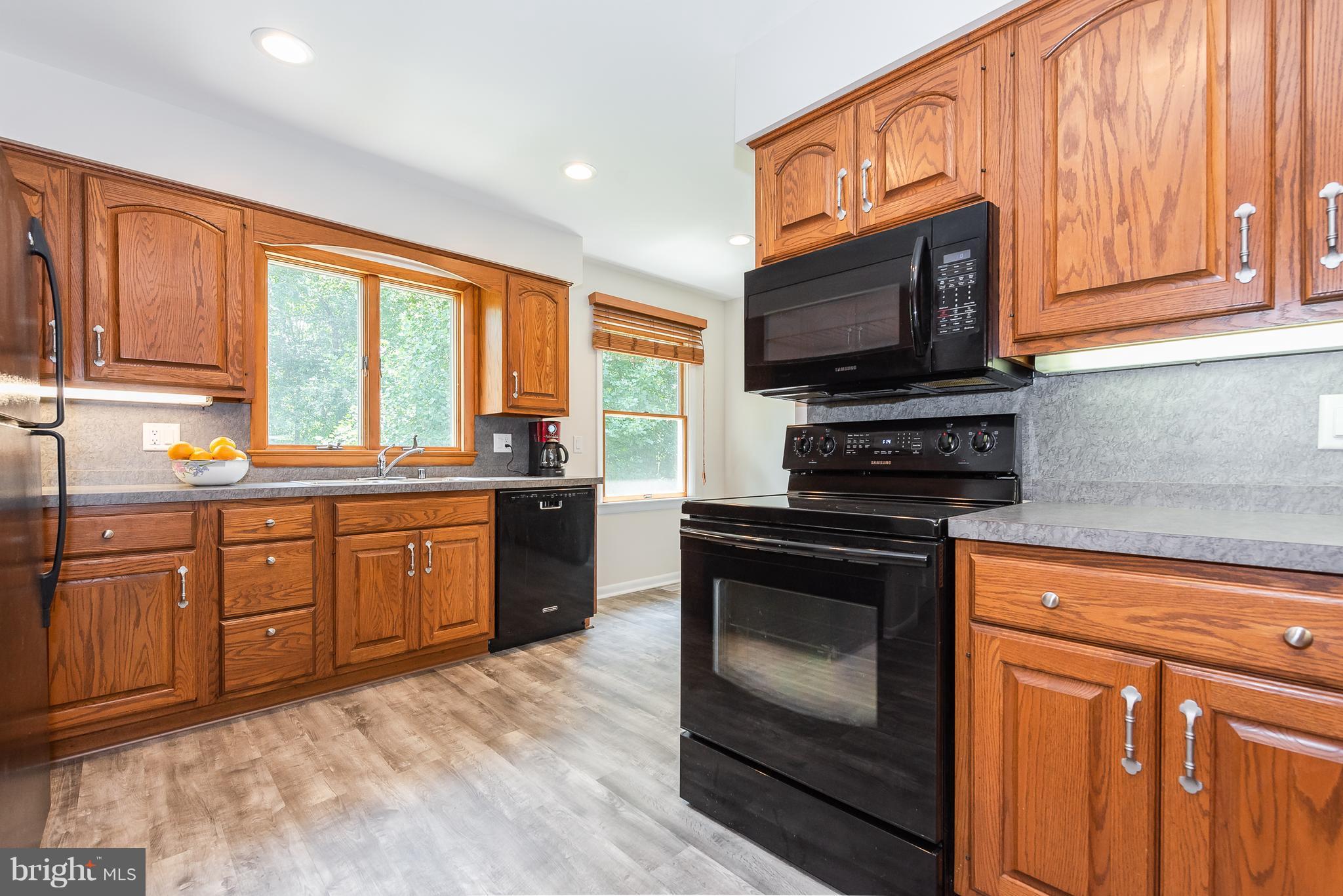 2103 Old Washington Road Westminster, MD 21157 - Photo 14 of 30 a kitchen with stainless steel appliances granite countertop a stove a sink dishwasher a microwave oven and cabinets with wooden floor
