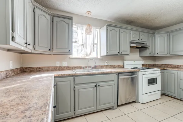 a kitchen with granite countertop cabinets stainless steel appliances and a sink