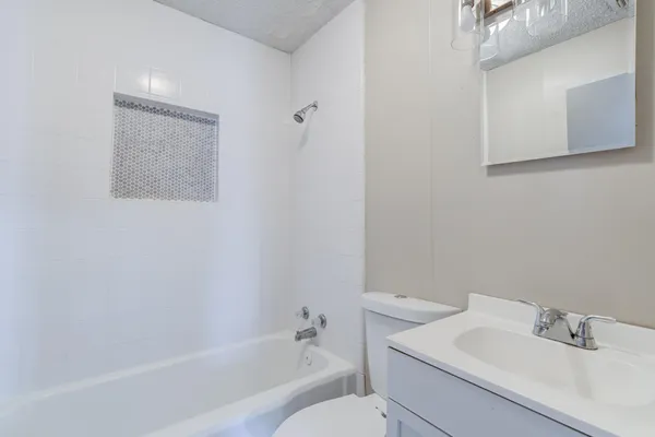 a white bath tub sitting next to a white sink and vanity