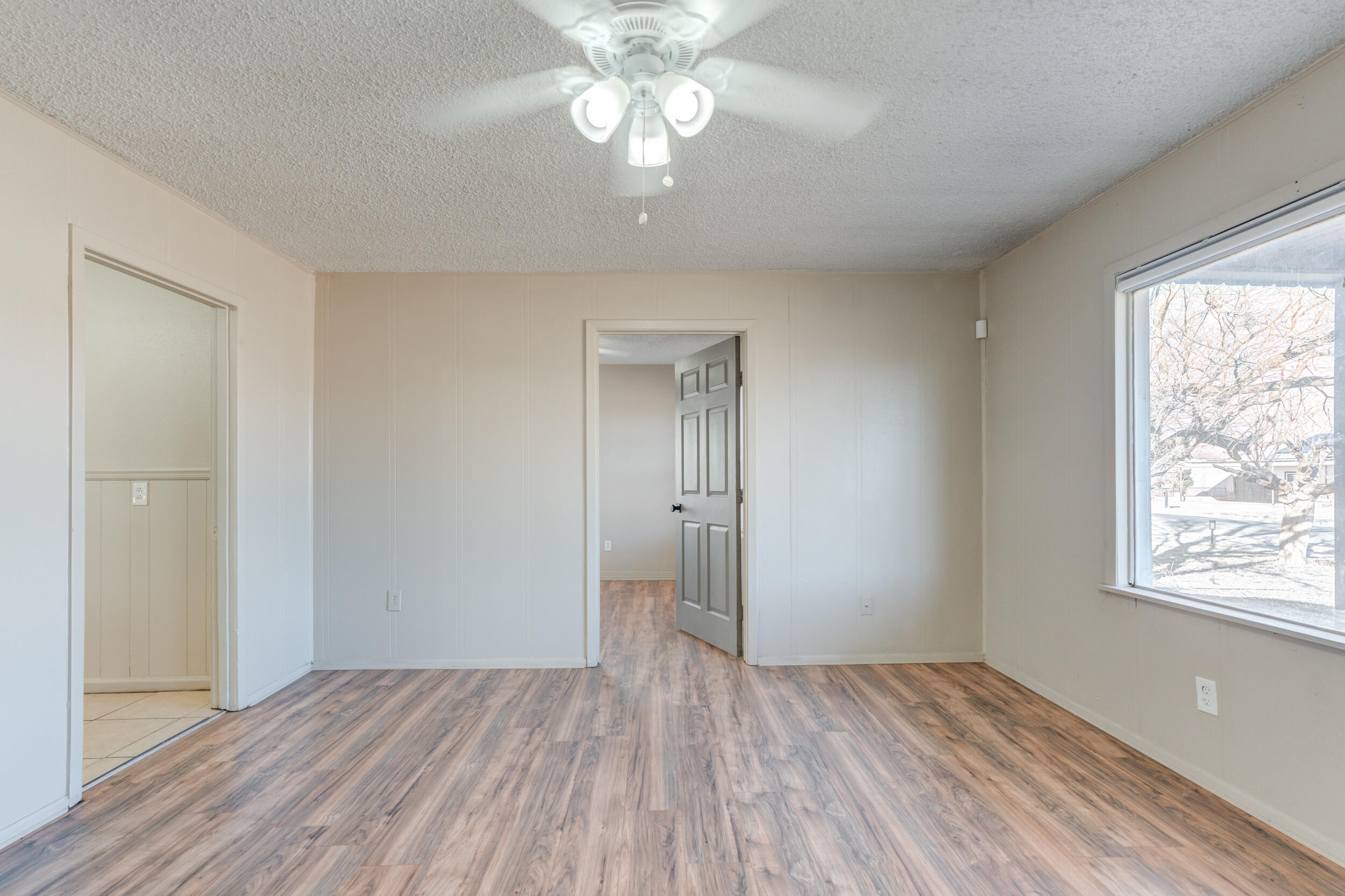 3109 Harvard Street Lubbock, TX 79415 - Photo 6 of 29 a view of an empty room with a window and wooden floor
