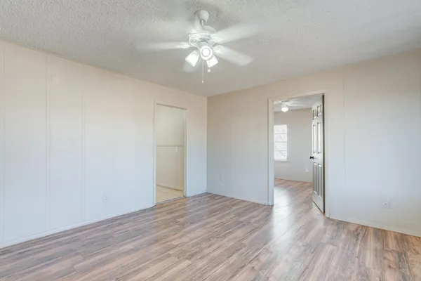 a view of an empty room with wooden floor