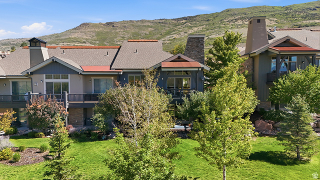 5207 North Oldgate Road Heber City, UT 84032 - Photo 52 of 58 Multi-level residence featuring balconies, a prominent stone chimney, and a landscaped backyard with mature trees