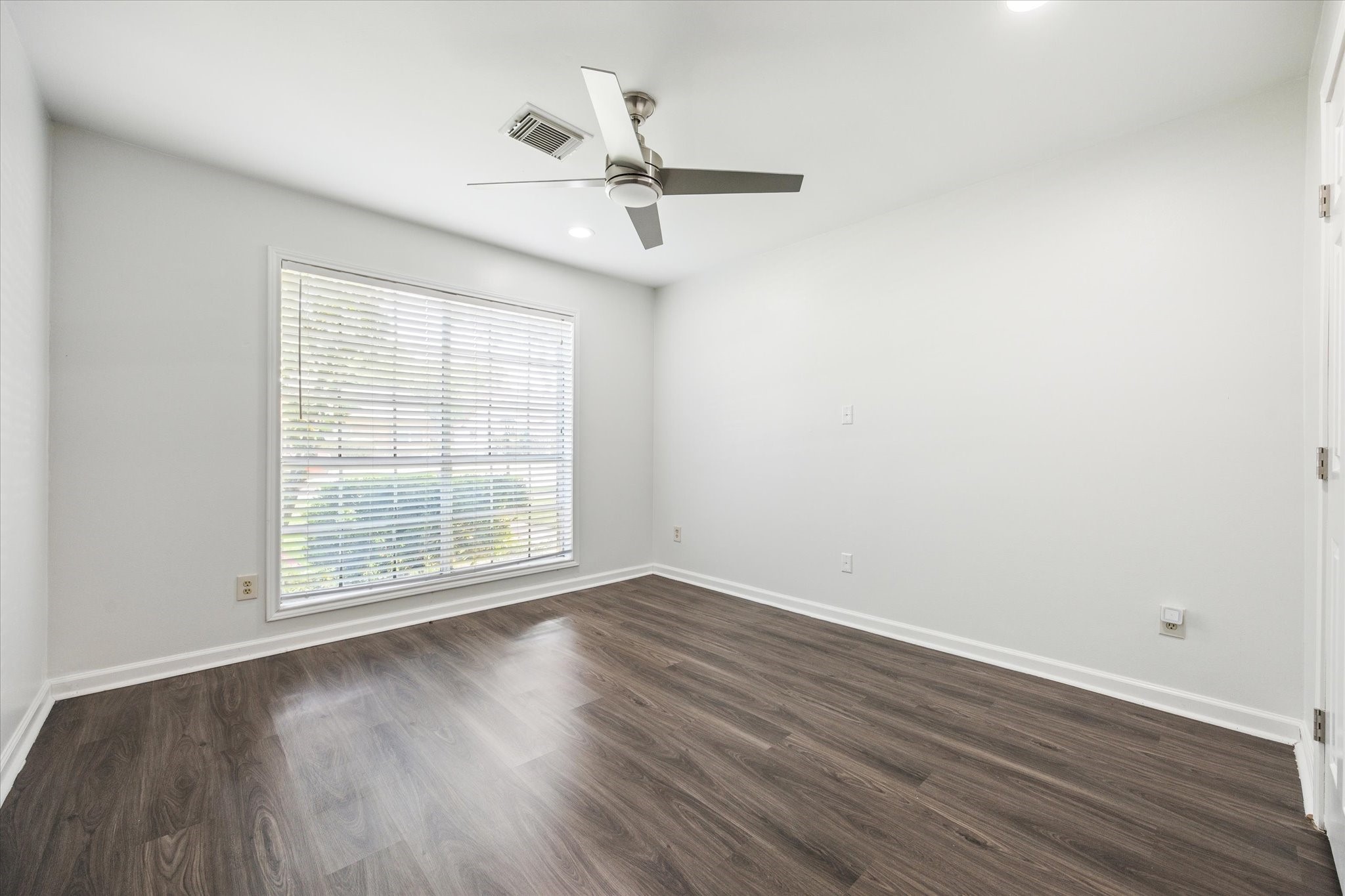 7614 Braesview Lane Houston, TX 77071 - Photo 21 of 29 an empty room with wooden floor fan and windows