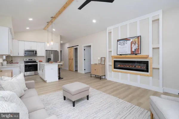 a living room with furniture and kitchen view