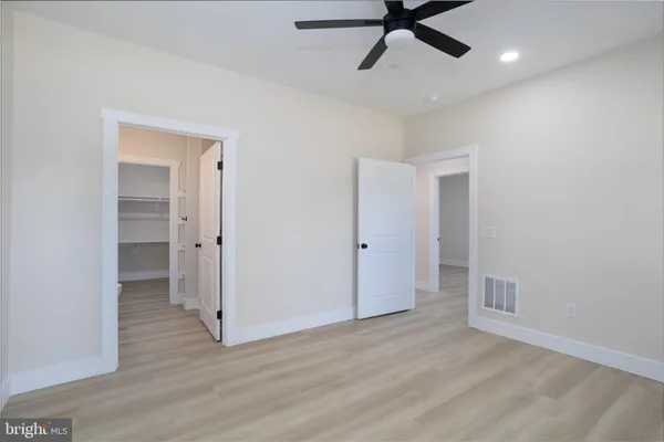 a view of a livingroom with a ceiling fan & entryway