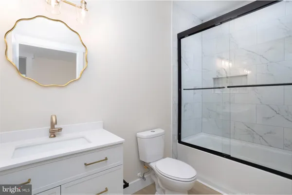 a bathroom with a sink a toilet and a mirror