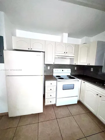 a kitchen with a white cabinets and white appliances
