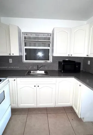 a kitchen with granite countertop a sink and a stove top oven