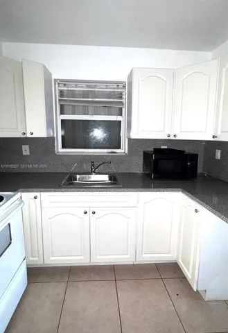 a kitchen with granite countertop a sink and a stove top oven