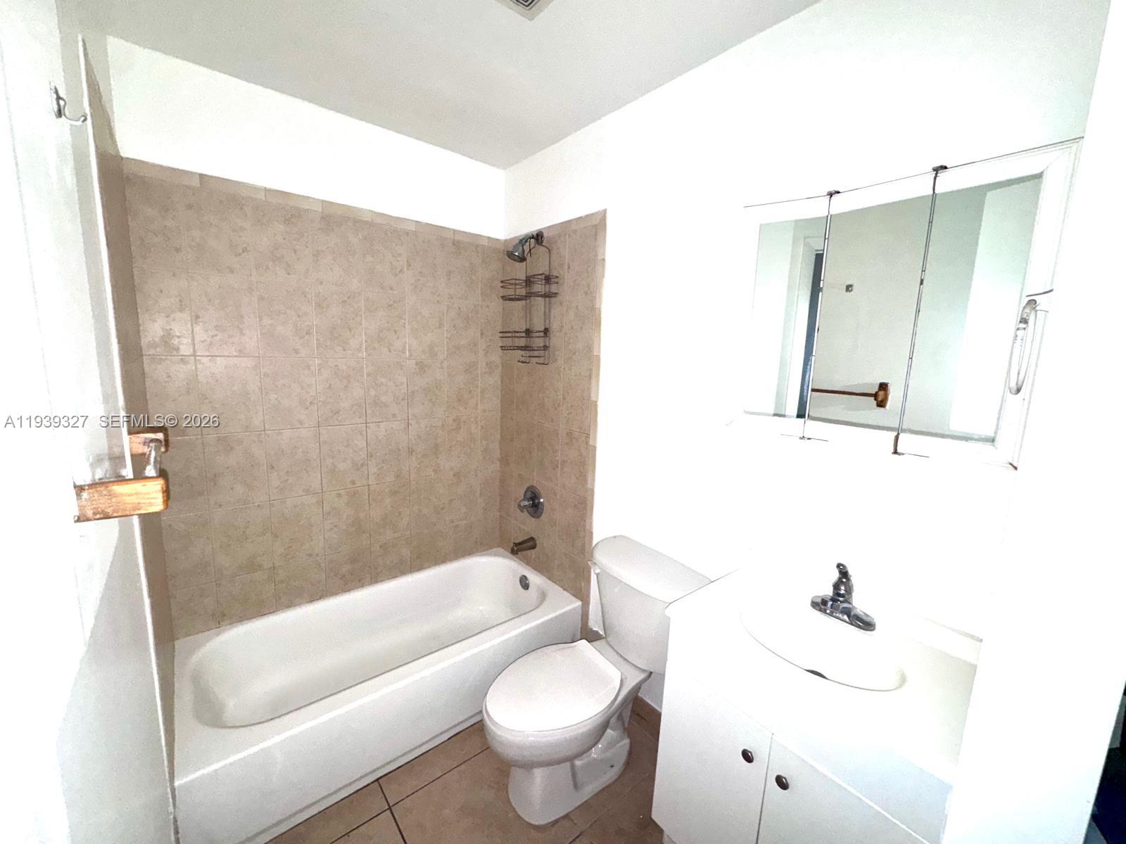 14140 Northeast 2nd Court, Unit 2 Miami, FL 33161 - Photo 6 of 13 a bathroom with a sink a toilet and shower