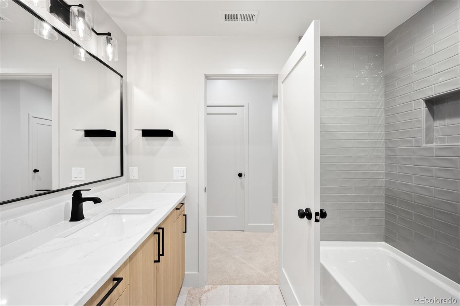 411 Madison Street Denver, CO 80206 - Photo 35 of 38 a bathroom with a sink a mirror and a bathtub