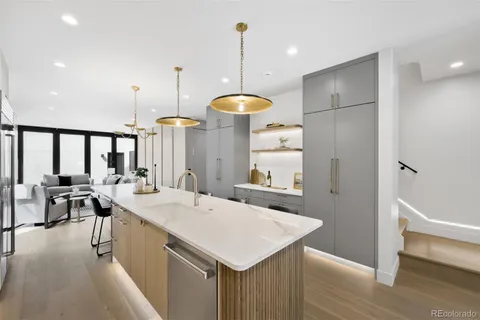a kitchen with a sink a refrigerator and wooden floor