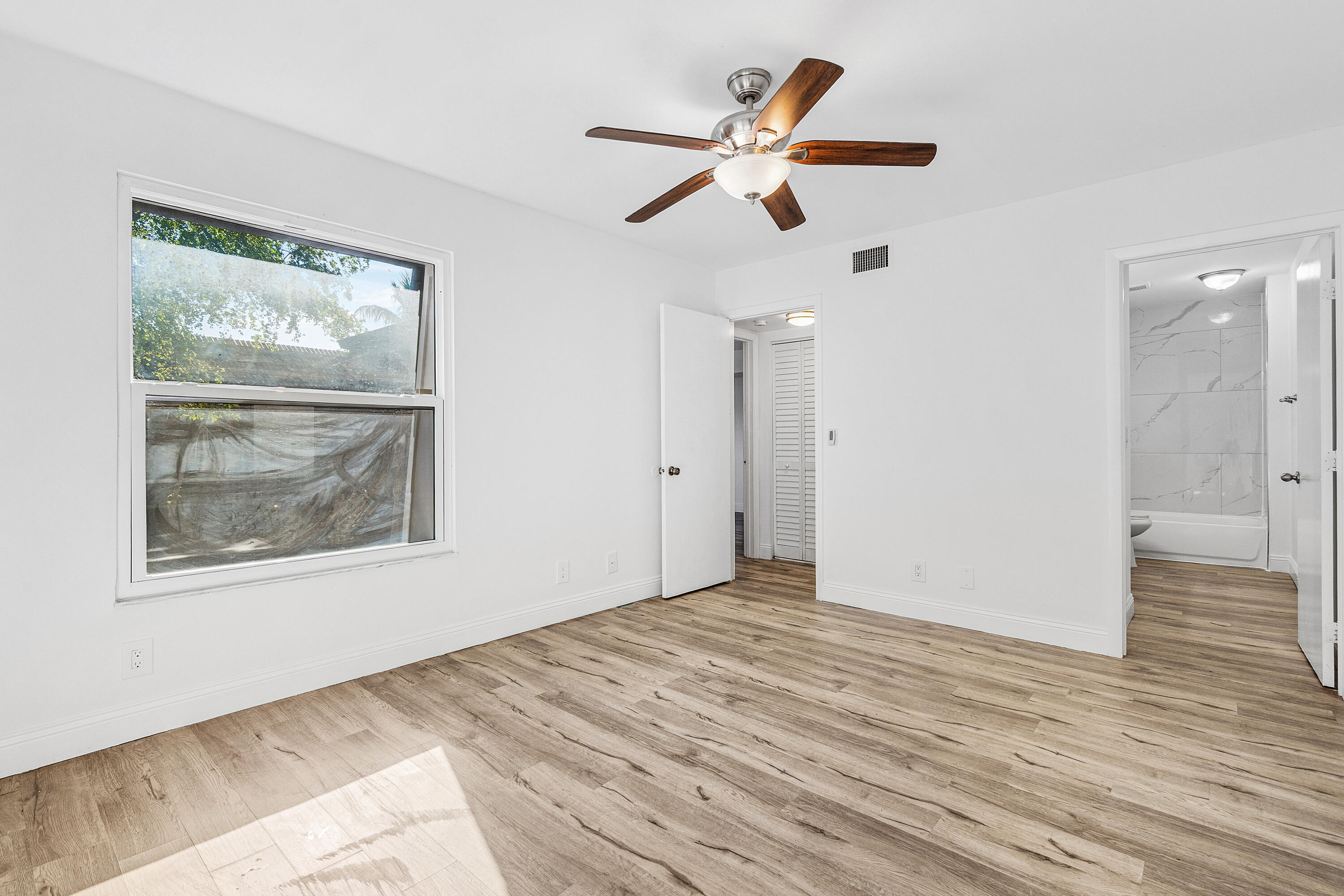 7536 Courtyard Run East Boca Raton, FL 33433 - Photo 20 of 25 a view of an empty room with wooden floor and a window