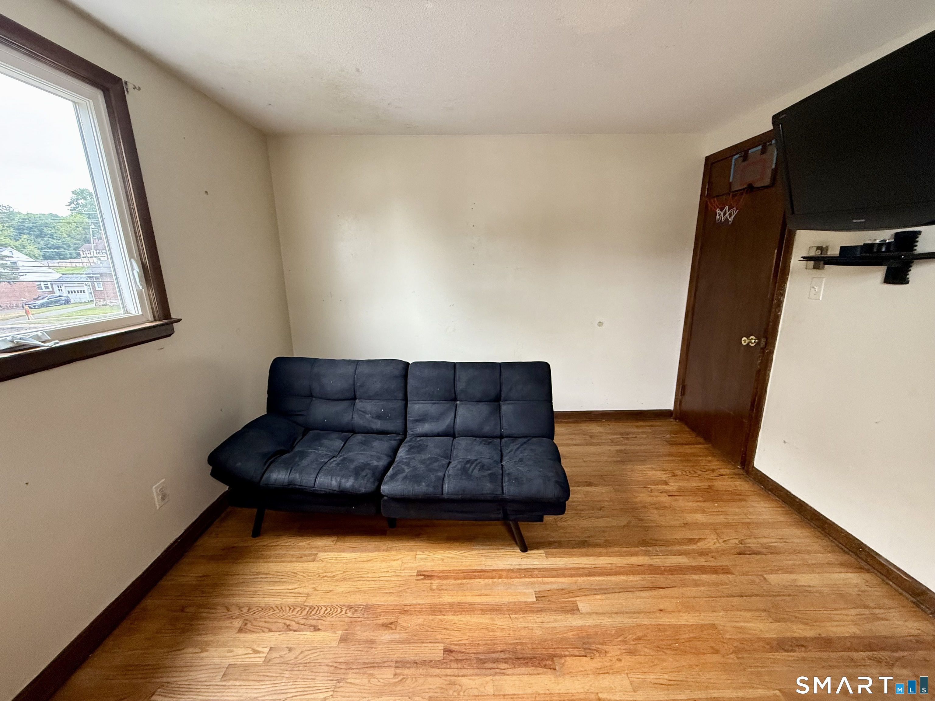 400 Divinity Street Bristol, CT 06010 - Photo 19 of 19 a living room with a bed furniture and a flat screen tv