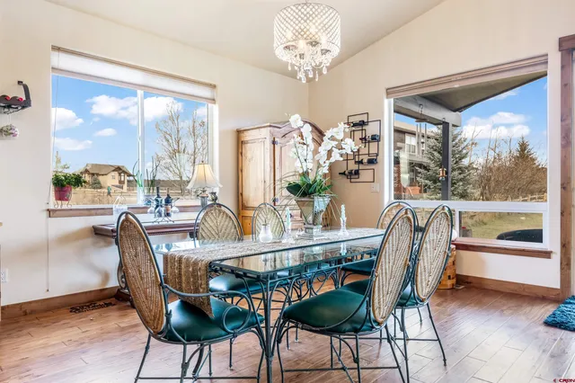 a dining room with furniture a chandelier and wooden floor