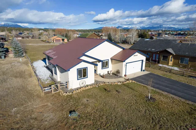 an aerial view of a house with yard and ocean view