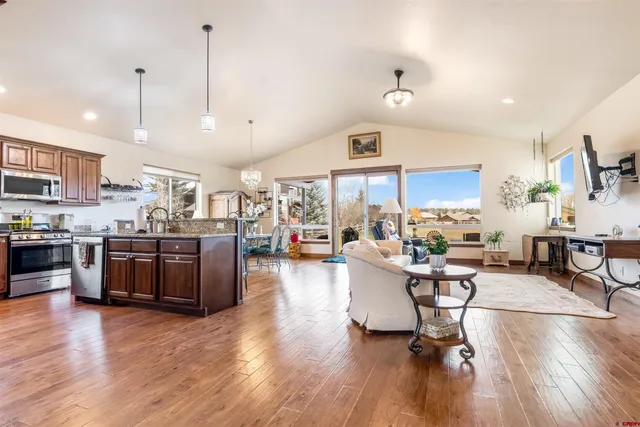 a living room with stainless steel appliances kitchen island granite countertop wooden floors and view living room