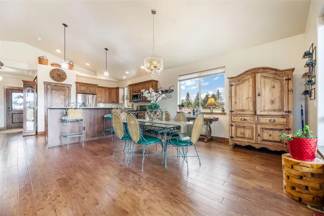 a view of a dining room and livingroom with furniture wooden floor a chandelier