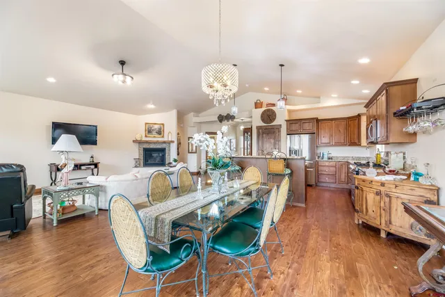 a very nice looking open dining room with kitchen island furniture a chandelier and a view of kitchen