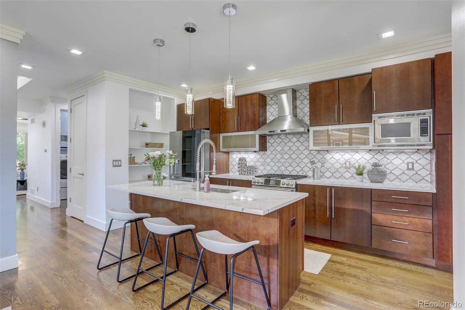 4238 Stuart Street Denver, CO 80212 - Photo 12 of 50 a kitchen with stainless steel appliances granite countertop wooden cabinets and counter space