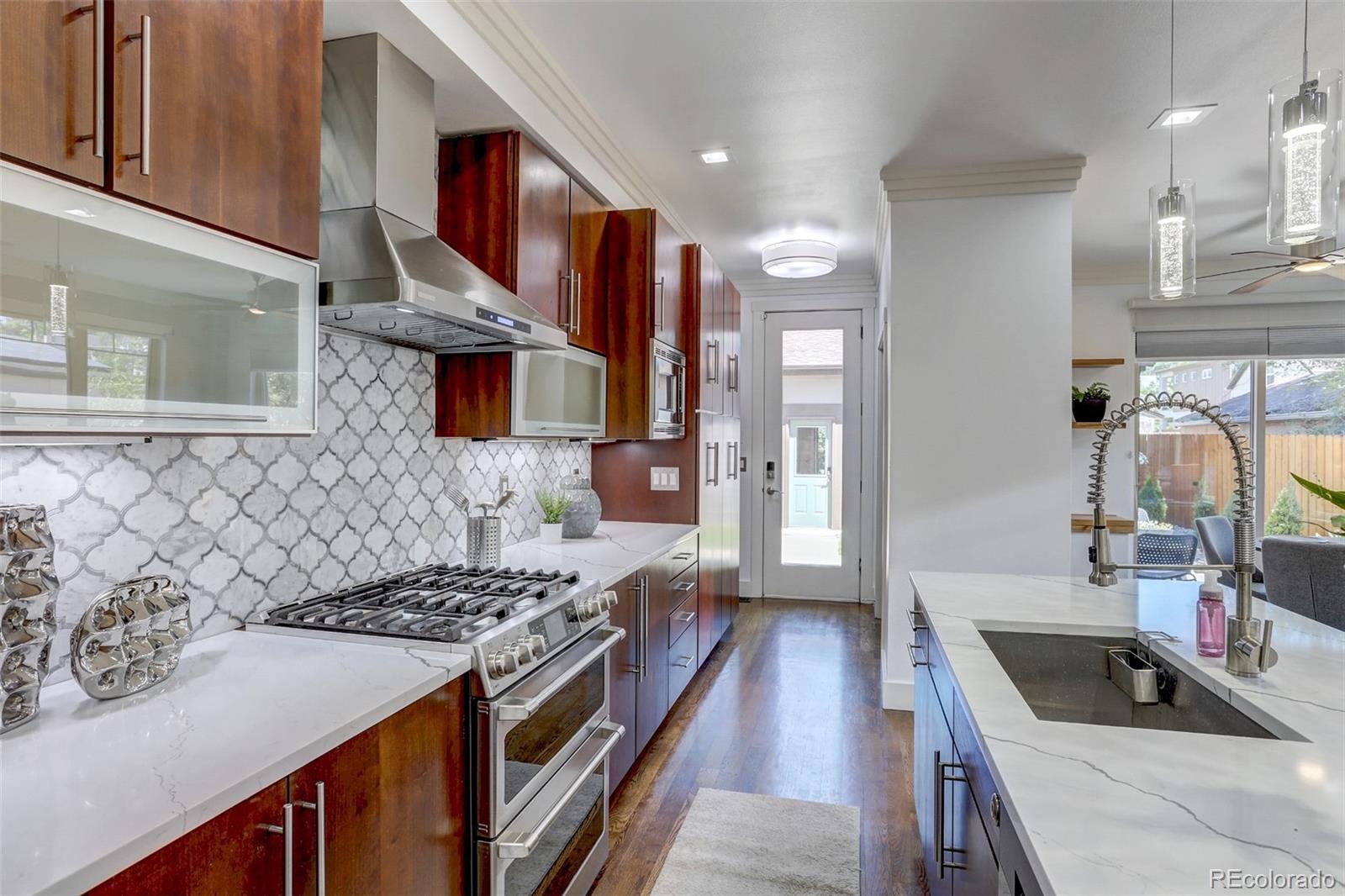 4238 Stuart Street Denver, CO 80212 - Photo 13 of 50 a kitchen with stainless steel appliances granite countertop a sink stove and refrigerator