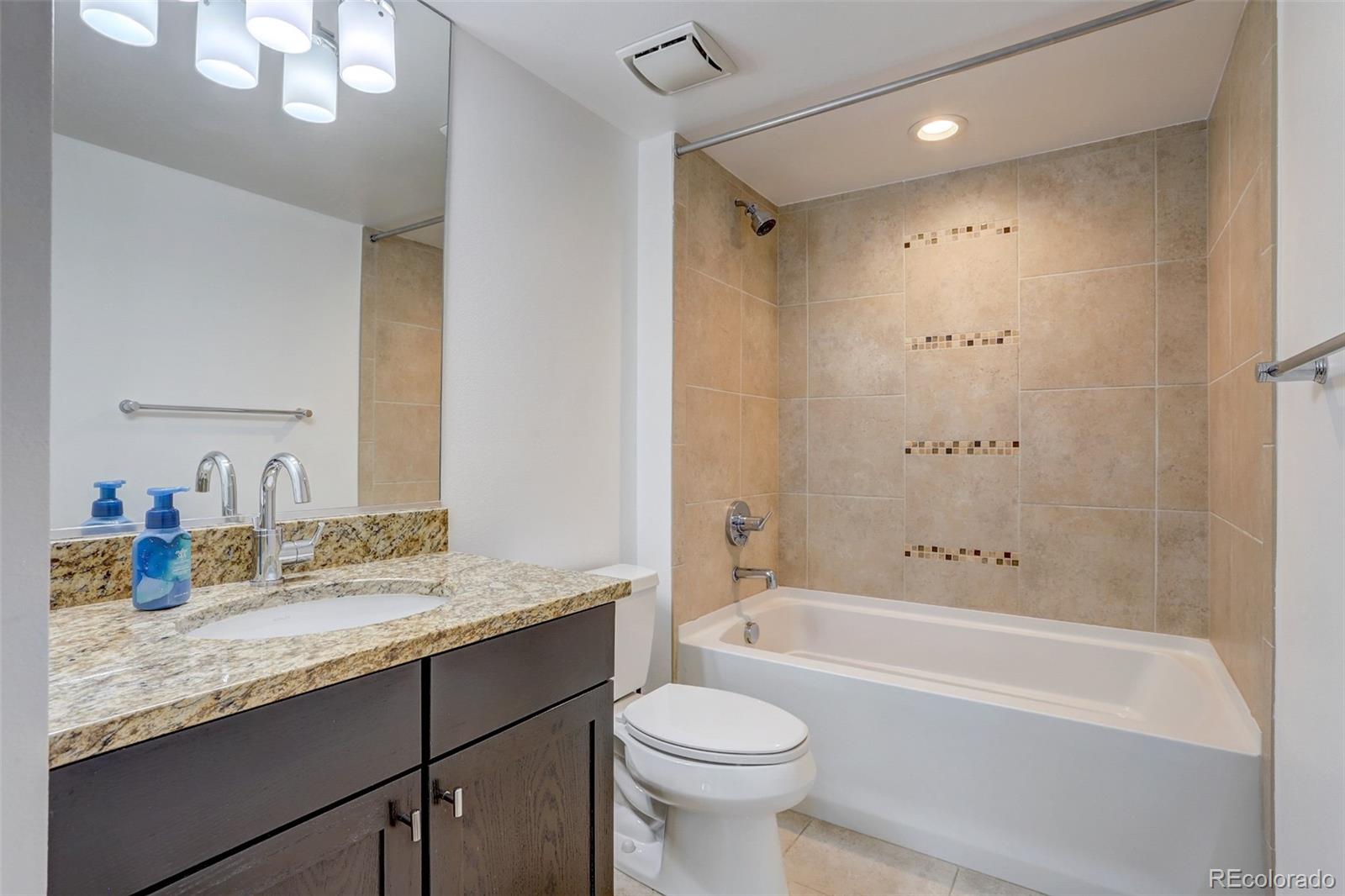 4238 Stuart Street Denver, CO 80212 - Photo 31 of 50 a bathroom with a granite countertop sink toilet mirror and bathtub