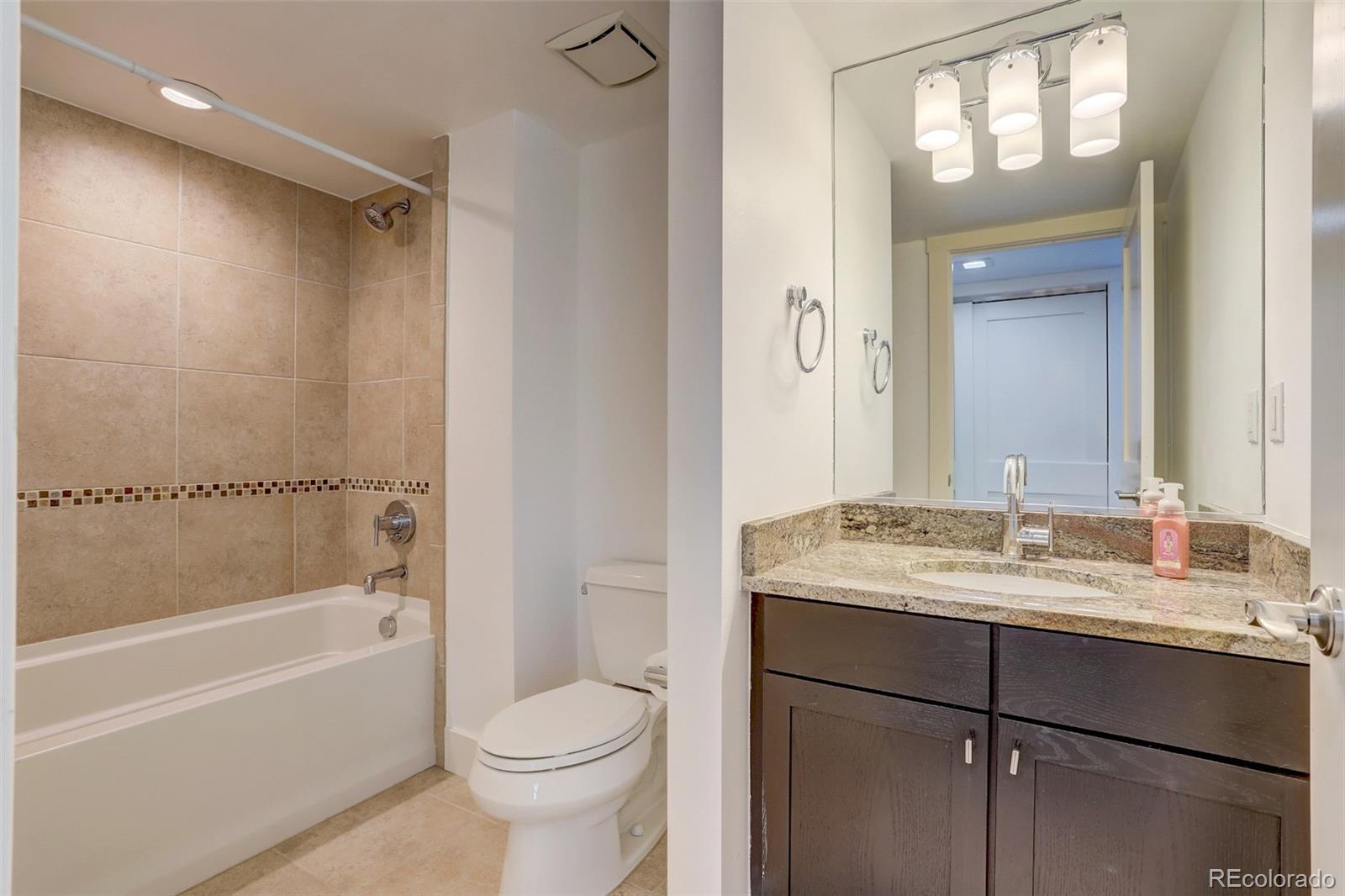 4238 Stuart Street Denver, CO 80212 - Photo 34 of 50 a bathroom with a granite countertop sink toilet and shower