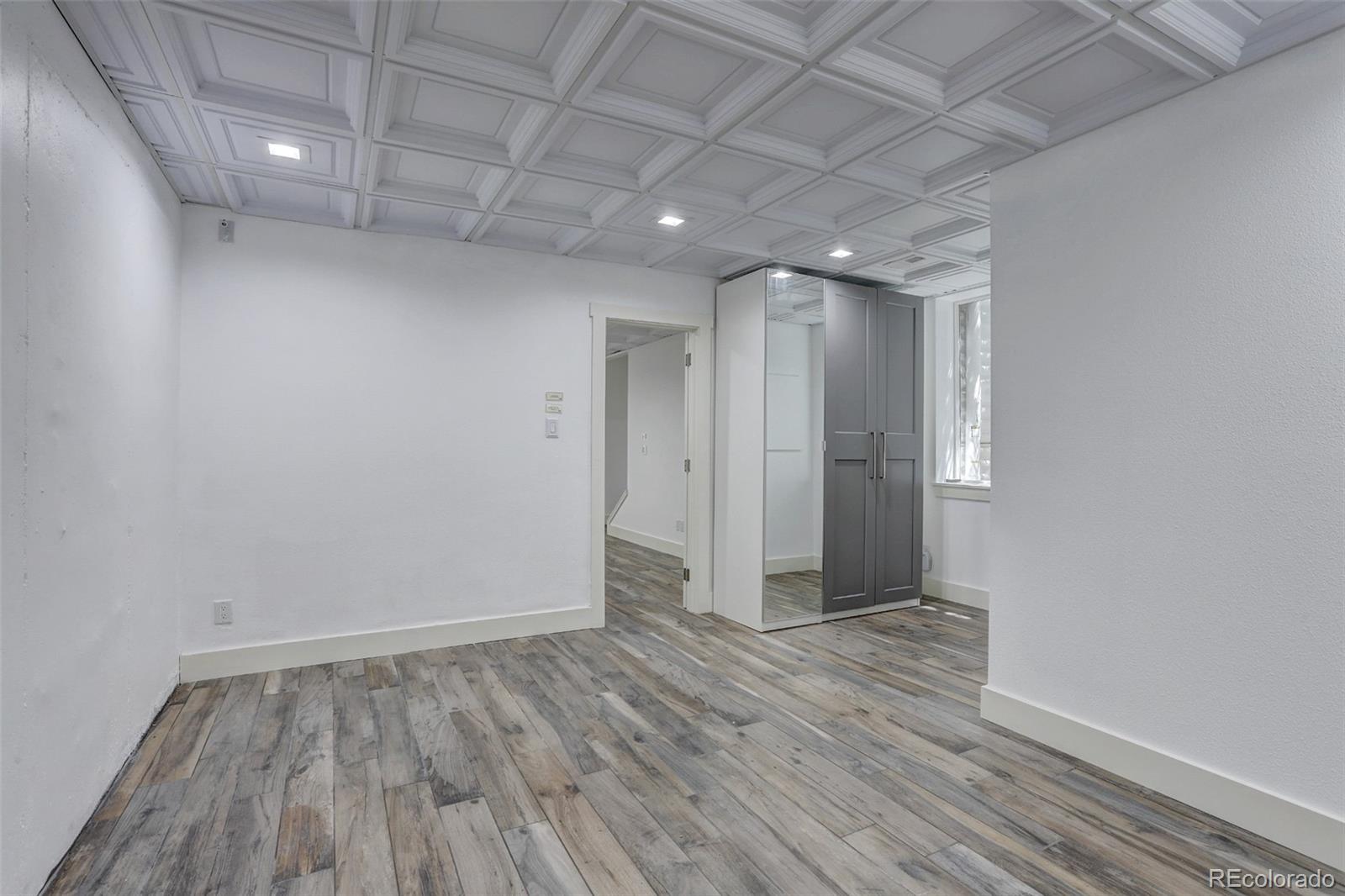 4238 Stuart Street Denver, CO 80212 - Photo 40 of 50 a view of hallway with an empty room and wooden floor