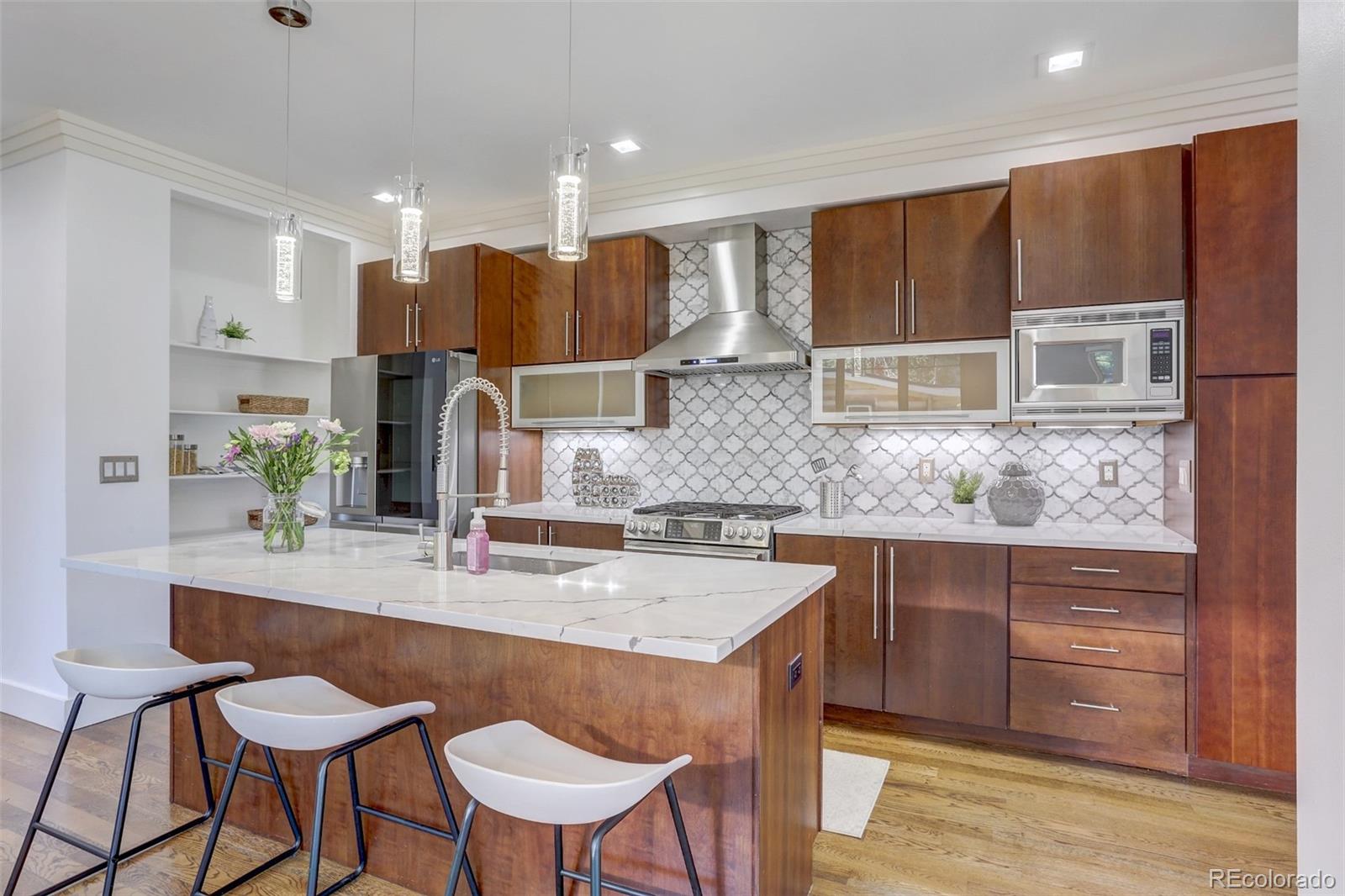 4238 Stuart Street Denver, CO 80212 - Photo 10 of 50 a kitchen with stainless steel appliances kitchen island granite countertop a sink and cabinets