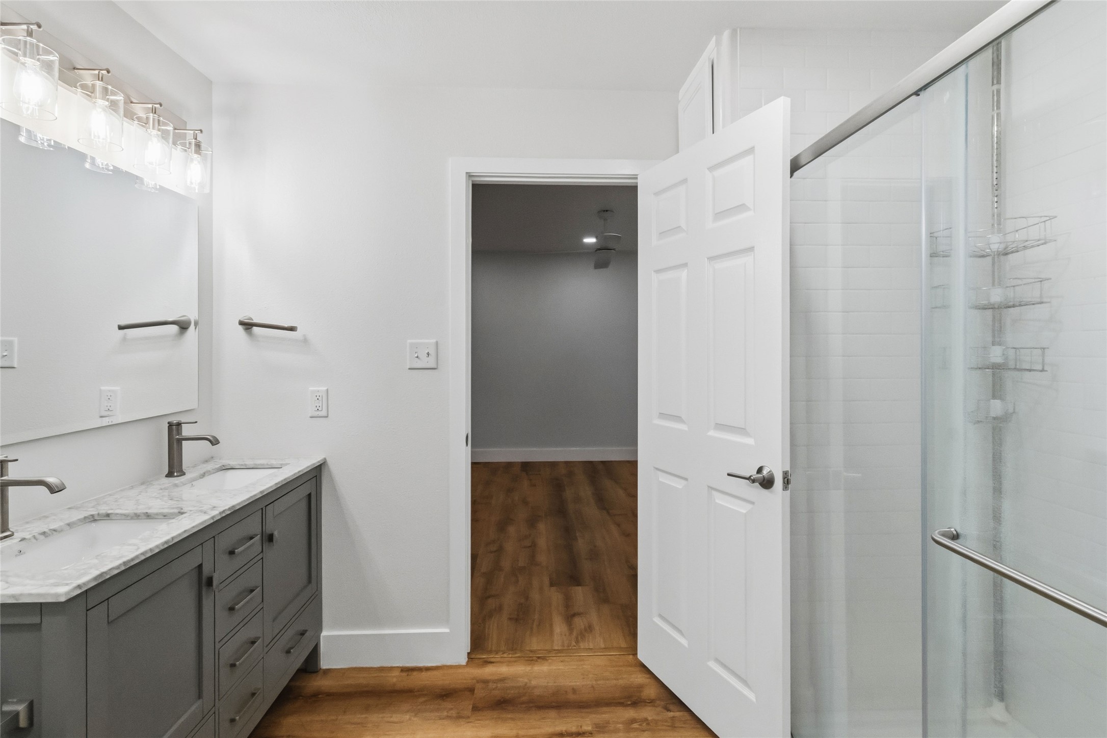 326 Pine View Loop Bastrop, TX 78602 - Photo 25 of 30 A well-appointed bathroom with a dual vanity, sleek marble countertops, and a clear glass shower.