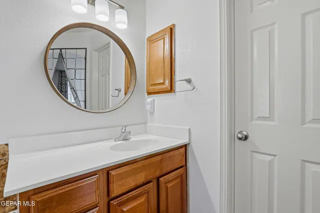 a bathroom with a sink a mirror and a painting on the wall