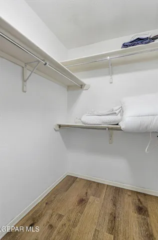 a view of a white house with a yard and table and chairs under an umbrella