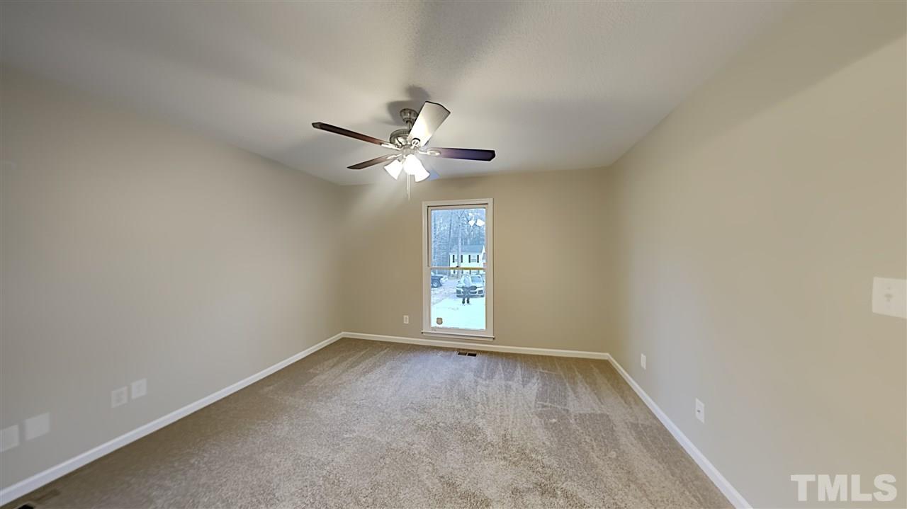 4225 Labrador Drive Raleigh, NC 27616 - Photo 8 of 13 an empty room with a chandelier fan and windows