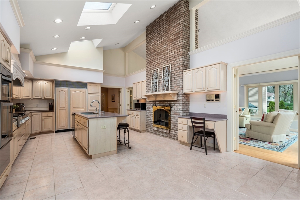 67 Bridle Path Sudbury, MA 01776 - Photo 14 of 42 a living room with furniture a fireplace and a kitchen view