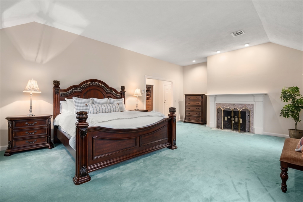 67 Bridle Path Sudbury, MA 01776 - Photo 19 of 42 a spacious bedroom with a bed and a fireplace