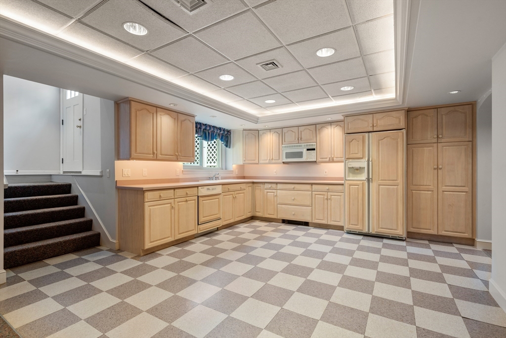 67 Bridle Path Sudbury, MA 01776 - Photo 29 of 42 a kitchen with a sink a stove a refrigerator and cabinets