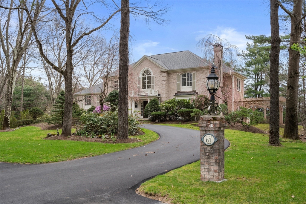 67 Bridle Path Sudbury, MA 01776 - Photo 38 of 42 a front view of a house with a yard fountain and a fountain