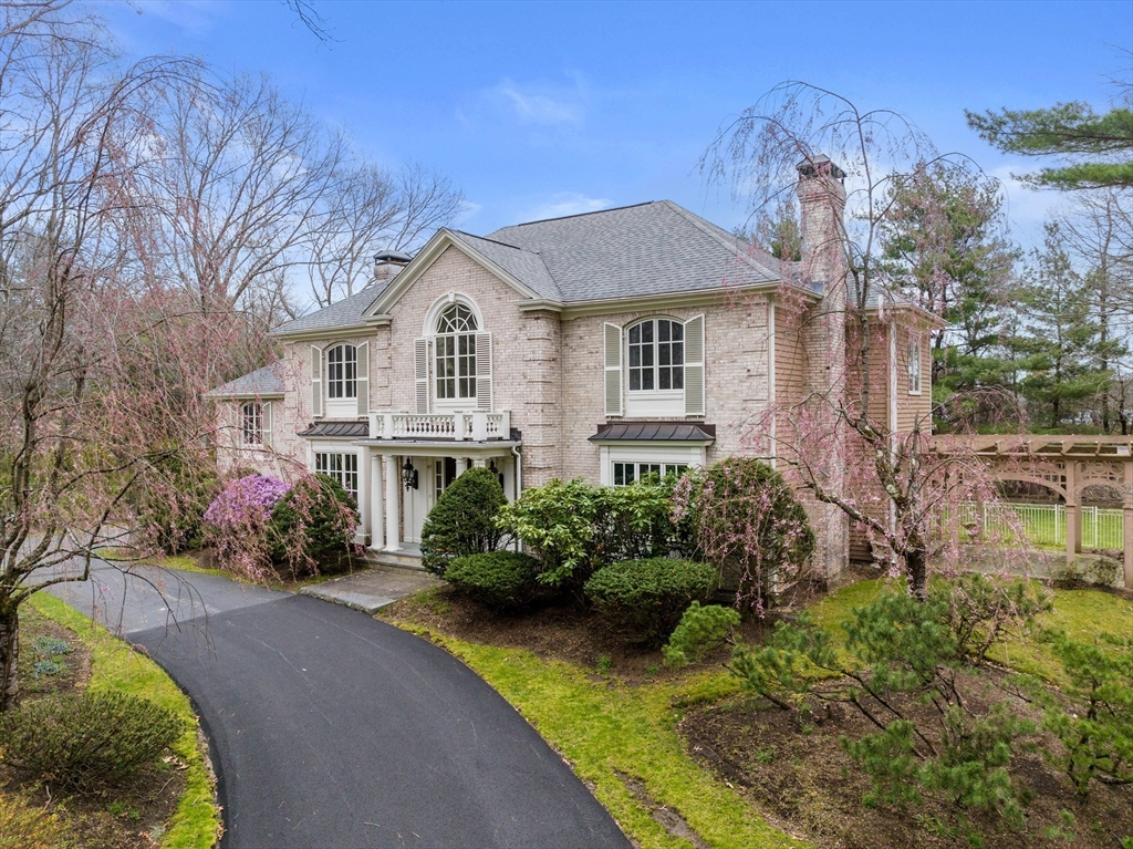 67 Bridle Path Sudbury, MA 01776 - Photo 39 of 42 a front view of a house with a yard and potted plants