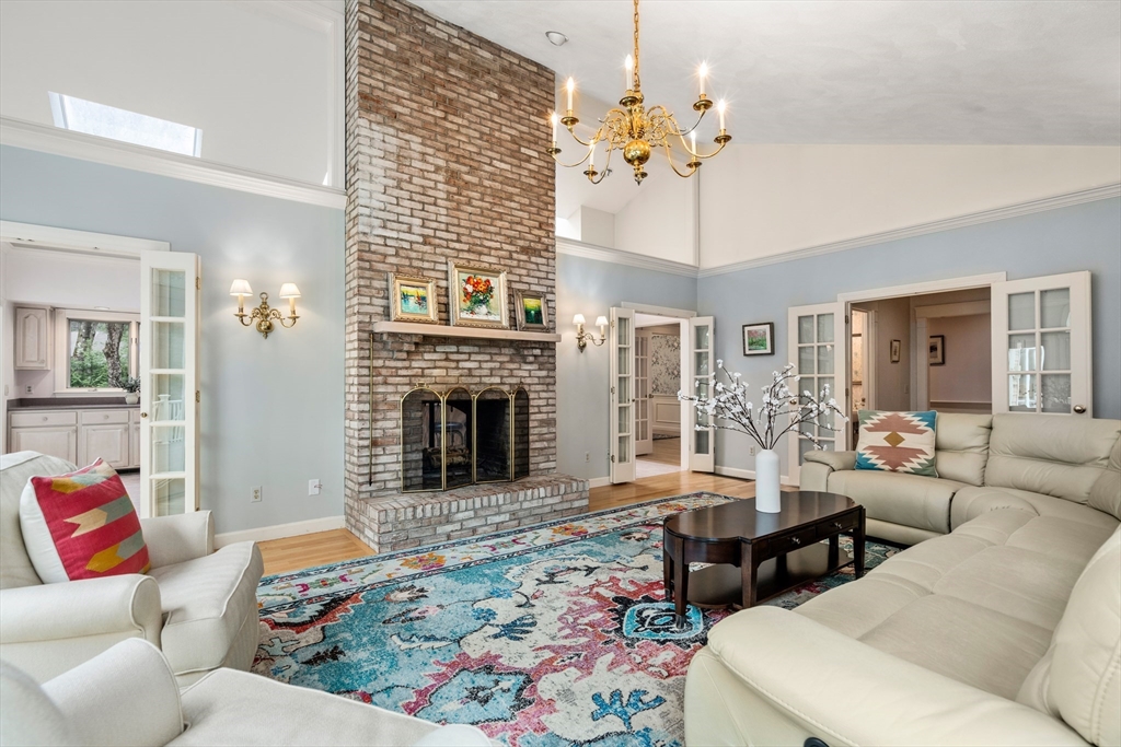 67 Bridle Path Sudbury, MA 01776 - Photo 6 of 42 a living room with furniture a fireplace and a chandelier
